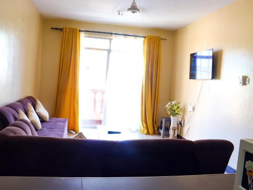 a living room with a couch and a large window at Beach Road Luxury Homes in Mombasa