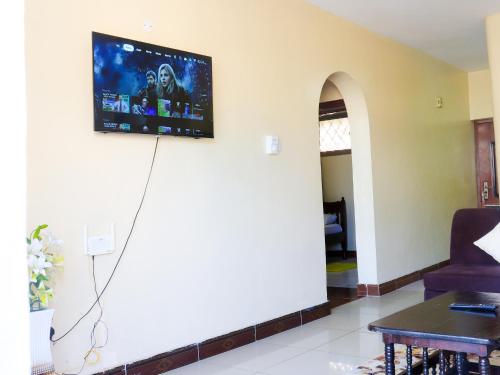 a living room with a tv on the wall at Beach Road Luxury Homes in Mombasa