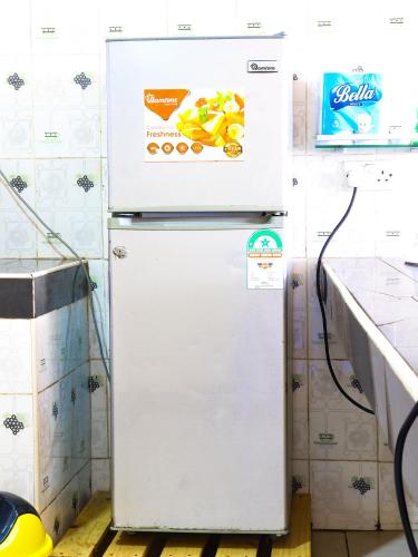 an old white refrigerator in a kitchen with a sticker on it at Beach Road Luxury Homes in Mombasa