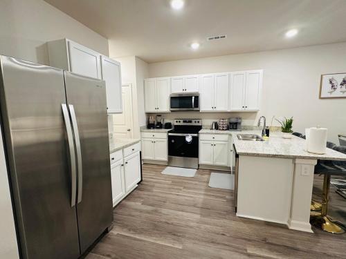 a kitchen with white cabinets and a stainless steel refrigerator at Modern comfort house in Madison
