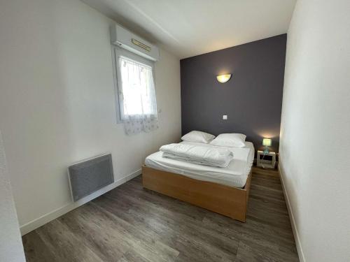 une petite chambre avec un lit et une fenêtre dans l'établissement Appt 2 pièces LA ROCHELLE - LR030-B225Z, à La Rochelle