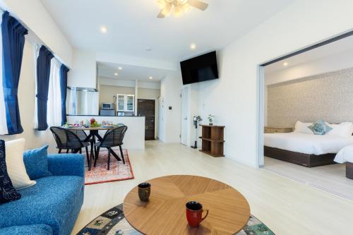 a living room with a blue couch and a table at Win-Akamine in Urasoe
