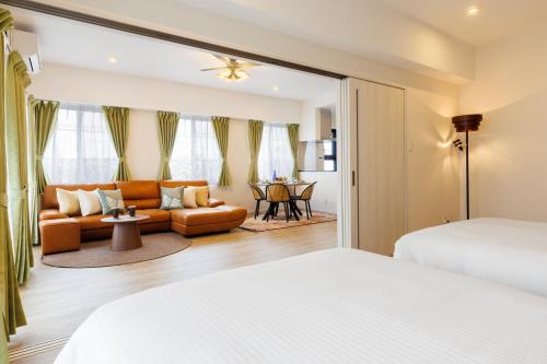 a bedroom with two beds and a living room at Win-Akamine in Urasoe