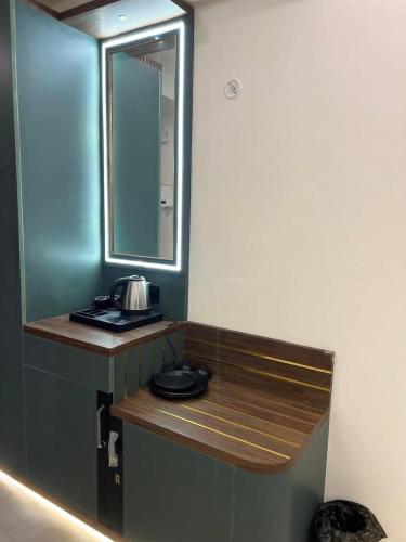ラクナウにあるMy Guest Stay at Omaxe Hazratganjの鏡と洗面台付きのカウンターがあるバスルーム