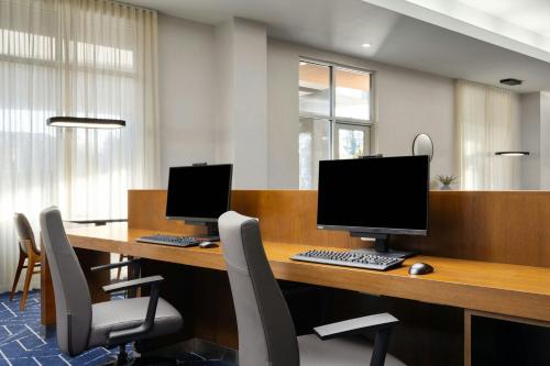 an office with two computers on a desk with chairs at Courtyard by Marriott Sunnyvale Silicon Valley in Sunnyvale