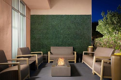 a patio with chairs and a table and a green wall at Courtyard by Marriott Sunnyvale Silicon Valley in Sunnyvale