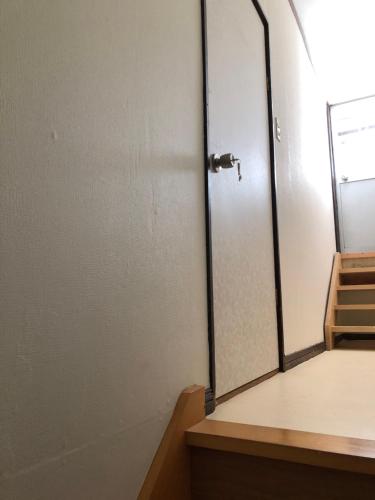 an empty room with a door with a mirror at Kakunodate Guesthouse Fuga in Senboku