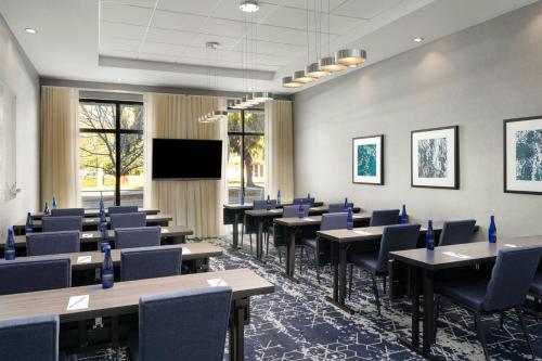 a conference room with tables and chairs and a screen at Courtyard by Marriott Sunnyvale Silicon Valley in Sunnyvale