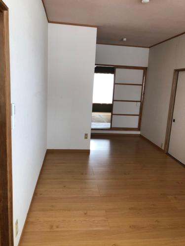 an empty room with white walls and a wooden floor at Kakunodate Guesthouse Fuga in Senboku