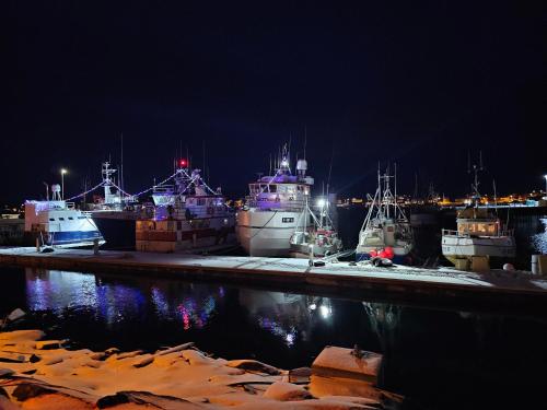 a group of boats docked in a harbor at night at Gamvik brakkebo as in Gamvik