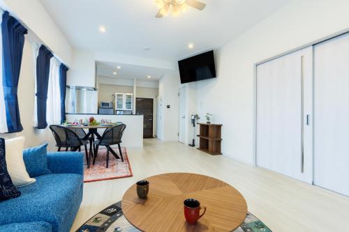 a living room with a blue couch and a table at Win-Akamine in Urasoe