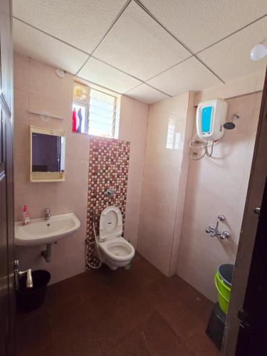a bathroom with a toilet and a sink at Cozy Apt Easy Access - Groceries & Transport in Mangalore