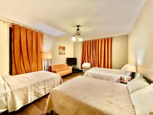 a hotel room with two beds and a couch at FAMILY Guest house in Newark