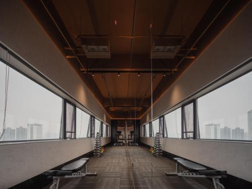 a view of a building hallway with chairs and windows at 欢桔酒店 郑州二七广场丹尼斯大卫城店 in Zhengzhou