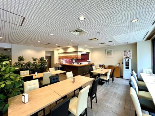 a restaurant with tables and chairs and a counter at Hotel Tetora Makuhari Inagekaigan (Formerly Business Hotel Marine) in Chiba