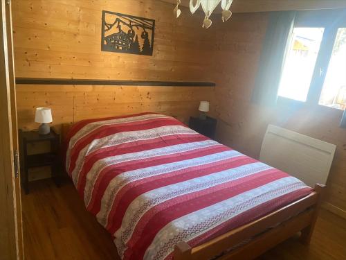 une chambre avec un lit avec une couverture rayée dans l'établissement Appartement dans les aravis, proche du Grand Bornand et de la Clusaz, à Entremont