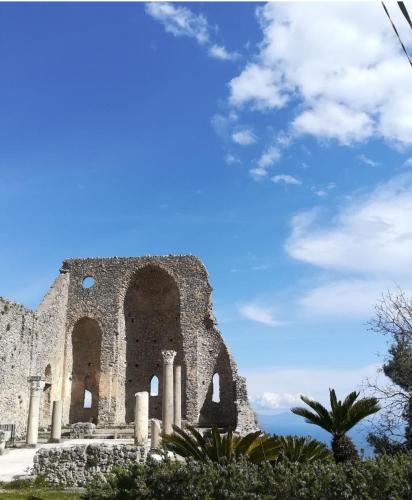 an old building with a blue sky in the background at Voce del Mare Apartment in Pontone