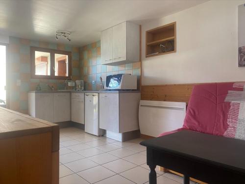 - une cuisine avec un canapé rouge dans une chambre dans l'établissement Appartement dans les aravis, proche du Grand Bornand et de la Clusaz, à Entremont