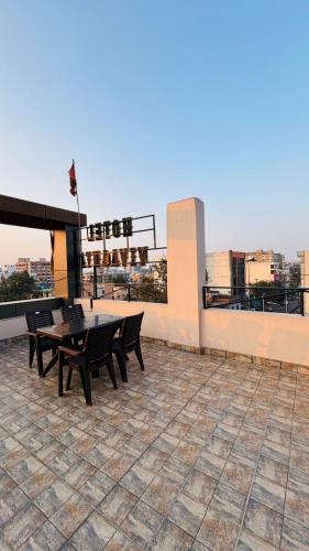 a patio with tables and chairs on top of a building at Hotel Vivaanta in Dhanbād