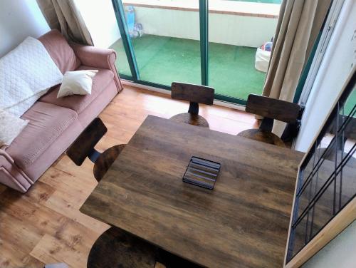 un salon avec une table en bois et un canapé dans l'établissement Le Cap'Océan, à Mimizan-Plage