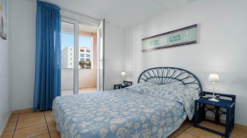 une chambre avec un lit et une grande fenêtre dans l'établissement Le Lamparo N201 - 2P4, au Cap d'Agde