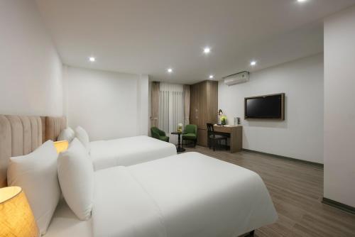 a hotel room with two beds and a television at Emissary Corner Hanoi Hotel & Spa in Hanoi