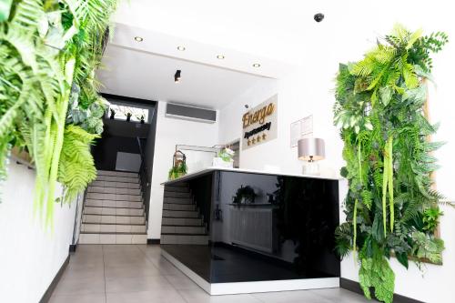 a lobby with plants on the walls and stairs at Apartamenty Energo in Bytom