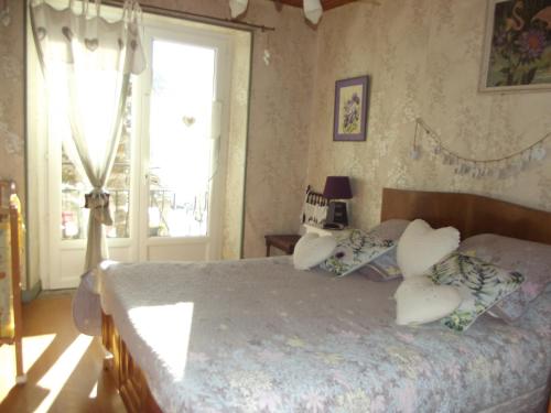 a bedroom with a bed with pillows and a window at gite au creux de la Vallée in Brezons