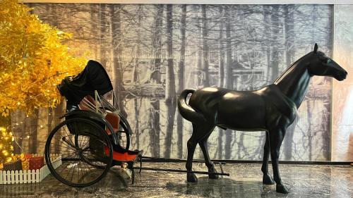 a statue of a horse standing next to a carriage at Paco Hotel GuangZhou Zoo Metro Branch Free shuttle bus during the Canton Fair in Guangzhou
