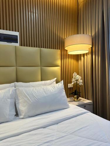 a bedroom with a white bed and a lamp at Perc Hotel in Pinamungahan