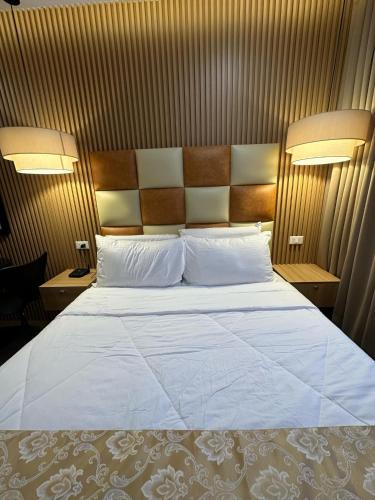a bedroom with a large bed and two night stands at Perc Hotel in Pinamungahan