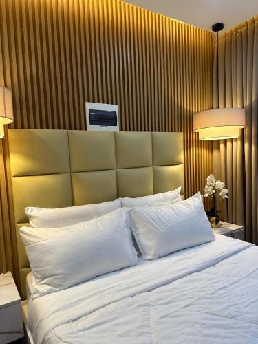 a bedroom with a large bed with white pillows at Perc Hotel in Pinamungahan