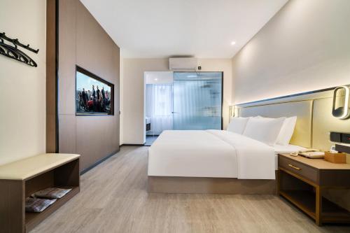 a bedroom with a large white bed and a desk at NICESOE Hotel - Chengdu Jianshe Road Electronic Science University in Chengdu