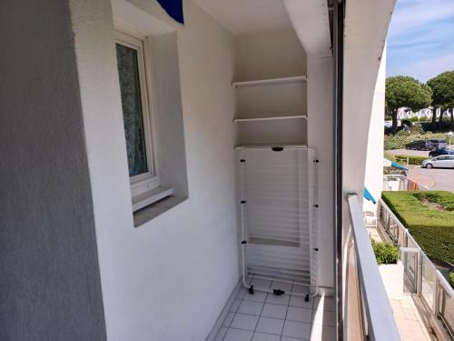 - un balcon avec un réfrigérateur sur le côté du bâtiment dans l'établissement Appartements proche des plages Avenue de l'Europe et rue des navigateurs, à La Grande Motte