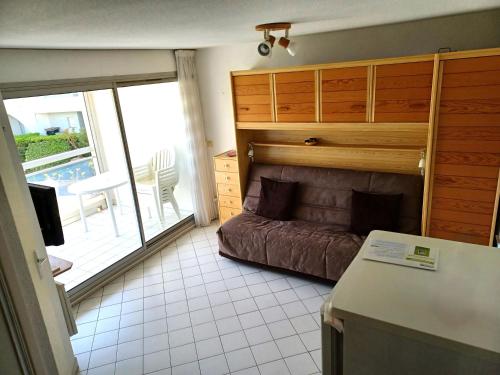 Cette petite chambre dispose d'un canapé et d'un balcon. dans l'établissement Appartements proche des plages Avenue de l'Europe et rue des navigateurs, à La Grande Motte