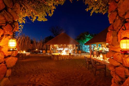 a night view of an outdoor dining area with tables and chairs at Leopard Hills Private Game Reserve in Sabi Sand Game Reserve