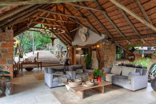 a living room with couches and a stone wall at Leopard Hills Private Game Reserve in Sabi Sand Game Reserve