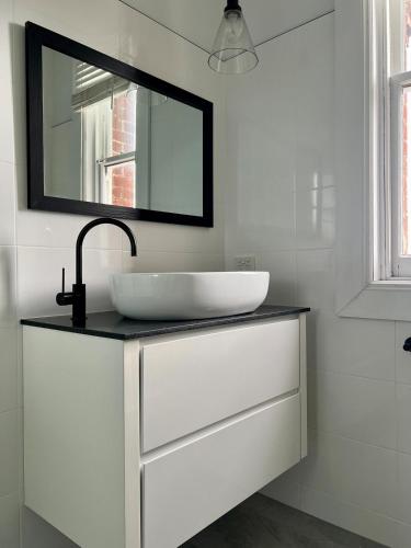 a bathroom with a sink and a mirror at Charming Heritage Home in Launceston