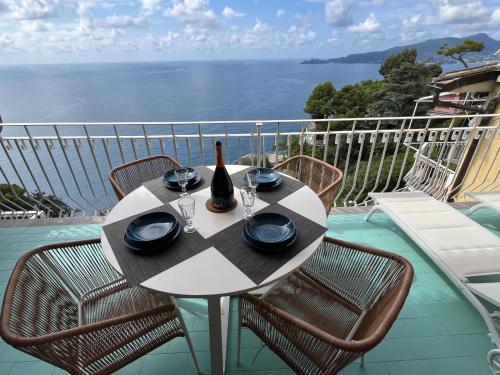 a table with a bottle of wine and glasses on a balcony at Tigullio Blue Experience - Portofino Luxury View in Villa Solari