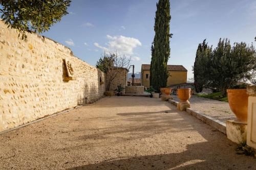 une ruelle avec un mur de pierre et un bâtiment dans l'établissement La Sousto de Lili, à Rasteau