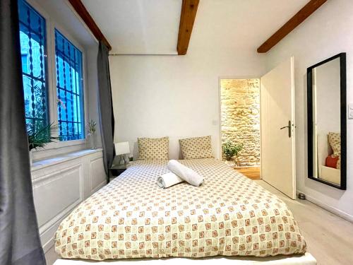 une chambre avec un lit dans une pièce avec des fenêtres dans l'établissement BnGo I Luxe & Confort I Lyon centre, 4 personnes, toilette séparé, Place des terreaux, à Lyon