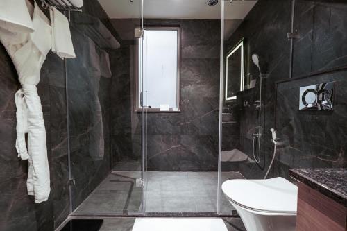 a bathroom with a glass shower stall and a toilet at Tree of Life Amara Resorts & Spa, Udaipur in Udaipur