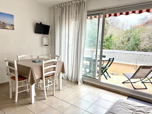 une salle à manger avec une table et des chaises et un balcon dans l'établissement Appartement studio centre Arcachon 4 pers terrasse, à Arcachon
