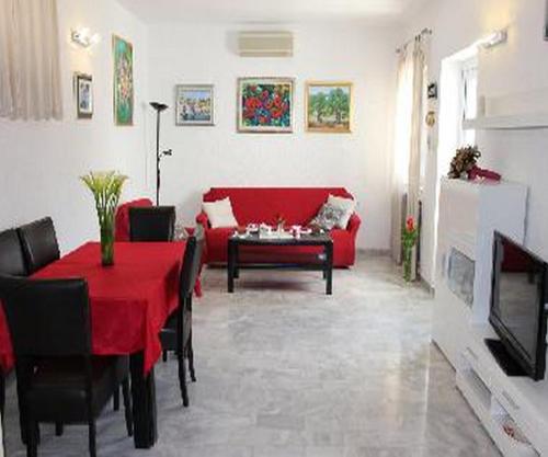 a living room with a red table and a red couch at Holiday Home Platanus in Trsteno