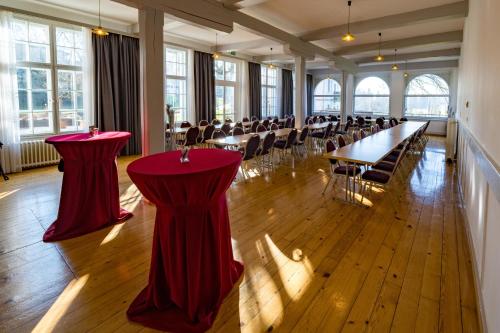 a large room with tables and chairs with red table cloths at Gasthof - Auszeit im Bad Diezlings - Adults only in Hörbranz