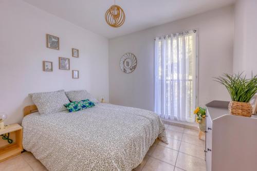 une chambre blanche avec un lit et une fenêtre dans l'établissement L'Orée du Cap - Climatisé proche plage, à Six-Fours-les-Plages