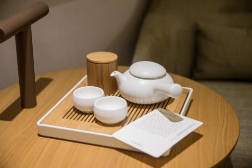 a table with a tea pot and cups on a tray at Ji Hotel Shanghai The Bund Jinling East Road in Shanghai