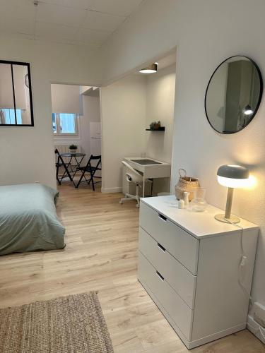 - une chambre avec une commode blanche et un miroir dans l'établissement Studio Cosy Le Guichard hyper center, à Bourg-en-Bresse