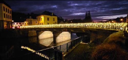 a bridge with christmas lights over a river at night at Gîte de l Archange in Josselin