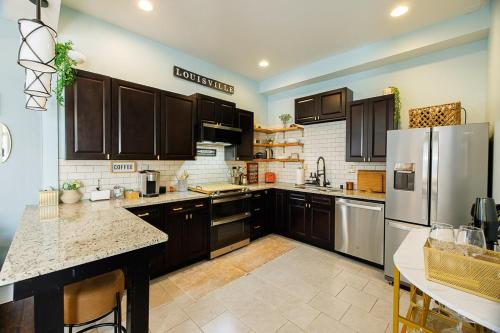 a kitchen with wooden cabinets and stainless steel appliances at Opulence On Oak Street in Louisville